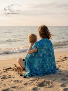 Mama-z-dzieckiem-siedząca-na-plaży-otulona-pareo-Save-the-ocean.jpg