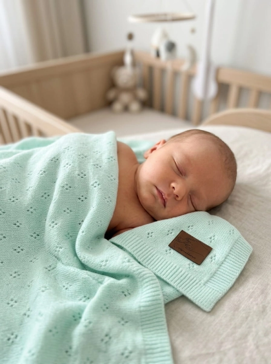 Baby_sleeping_on_mint_blanket_202606111920 (1).jpeg